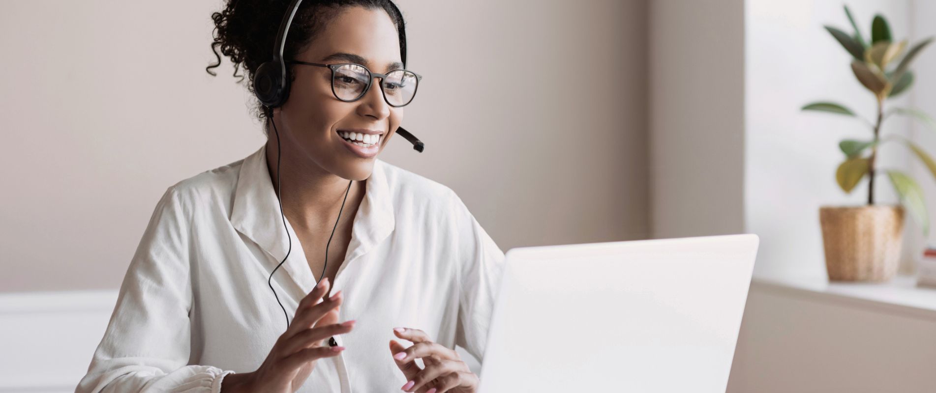 Woman at her laptop talking through a headset