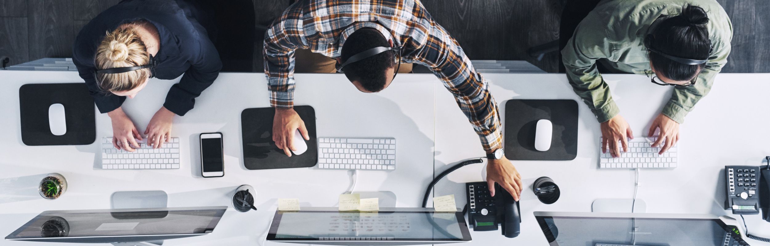 individuals working together and offering assistance on the computer