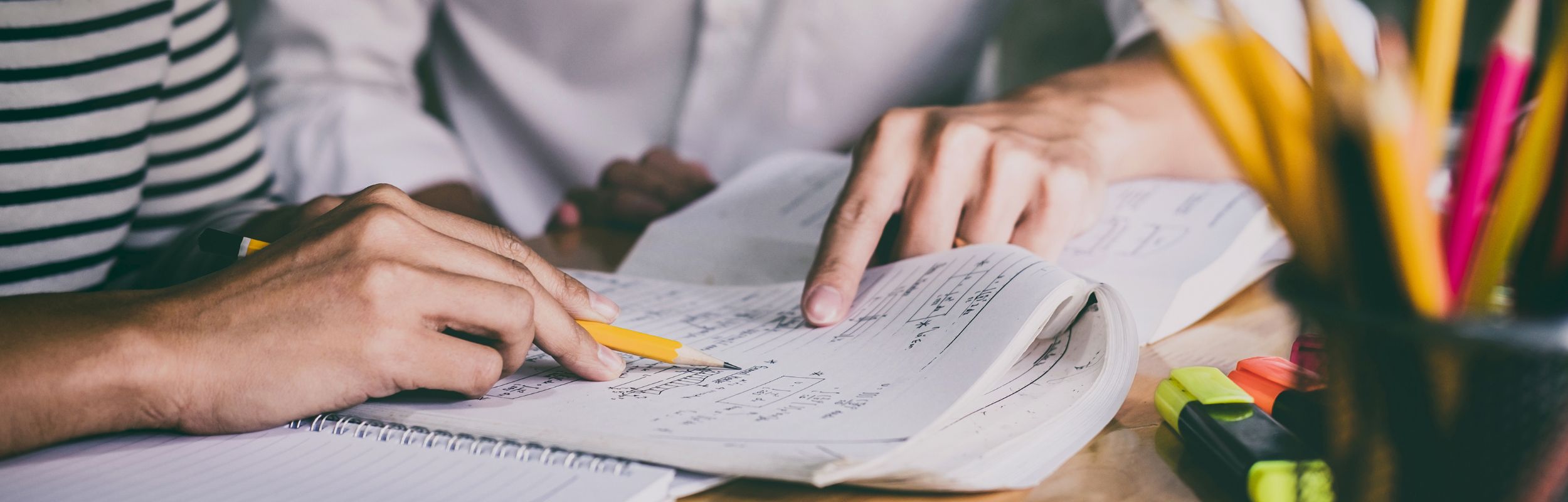 Close up of two people working on a math equation.