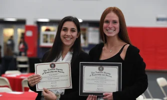 two students holding their diploma